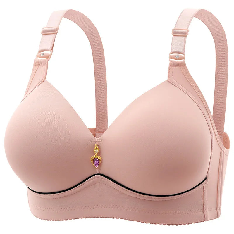 A beige, wire-free, thin cup bra with a heart charm on the clasp.