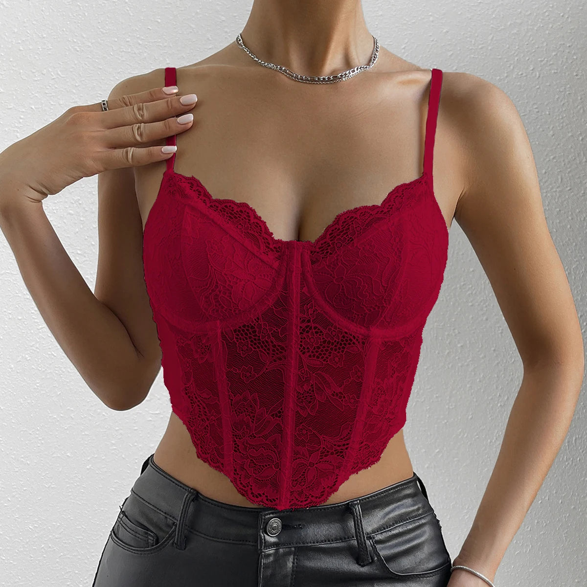 A red lace embroidered v-neck corset crop top with spaghetti straps and a deep v-neckline, worn by a model.